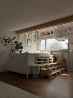 a bedroom with wooden pallets and plants on the window sill next to it