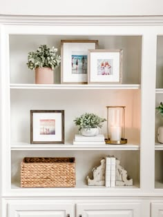 a white book shelf filled with books and pictures on top of each other, next to a wicker basket