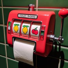 a red toilet paper dispenser in a green tiled bathroom with fruit and lemons on it