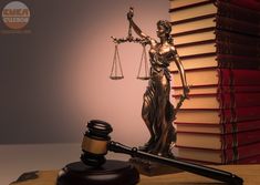 a statue of lady justice next to a stack of law books and a gavel