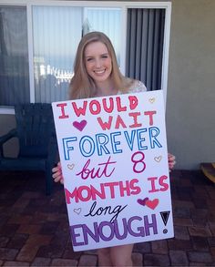 a girl holding a sign that says i would wait forever but 8 months is long enough