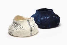 two pairs of slippers sitting next to each other on a white surface with blue and black designs