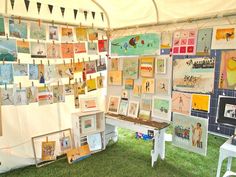 there are many pictures hanging on the wall in this tent, and one has a bench underneath it