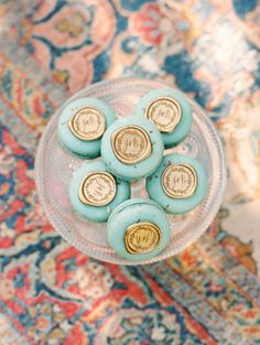 blue and gold buttons sitting on top of a glass plate in front of a rug