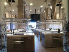 a large kitchen filled with lots of counter top space next to a tv mounted on the wall