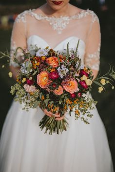 a woman holding a bouquet of flowers in her hands