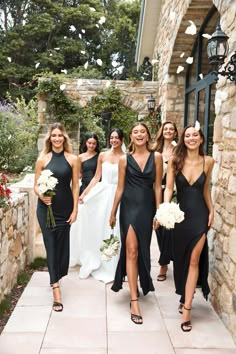 a group of women in black dresses standing next to each other