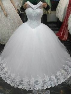 a white ball gown is on display at a wedding dress shop with mannequins in the background