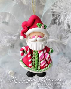 a christmas ornament with a santa clause on it's face and candy canes in his hand