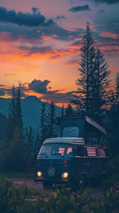 a van is parked on the side of a road at sunset with mountains in the background