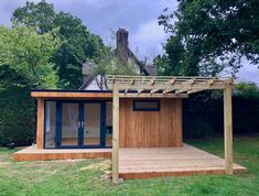 a small wooden structure in the middle of some grass