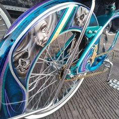 a blue bicycle with skulls painted on it's front wheel and rear tire rims