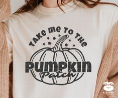 a woman wearing a white shirt with the words take me to the pumpkin patch on it