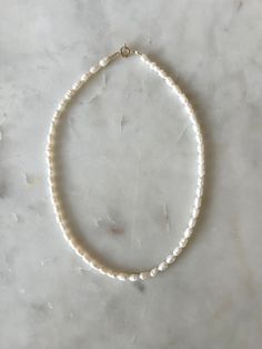 The Chelsea Dainty Pearl Necklace features tiny fresh water pearls that resemble a fresh shell just washed up from the ocean.  Secured by a gold-filled clasp that won't tarnish in sweater or water.  Available in 15", 16" or 17" in length. Handmade Delicate Pearl White Pearl Necklace, Dainty Baroque Pearl Necklace In Pearl White, Fresh Water Pearl Necklace, Summer Beach-appropriate Pearl Chain Necklace, Classic 14k Gold-filled Pearl Necklace, Dainty Pearl Necklace, Freshwater Pearl Necklaces, Chain Ring, Star Necklace