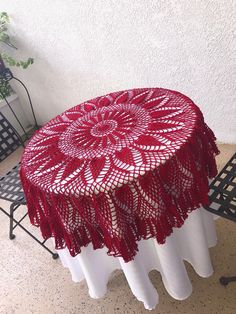 a red doily tablecloth on top of a white table