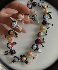 a close up of a person's hand on a plate with beads and rings