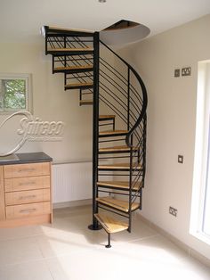 a spiral staircase in the corner of a room next to a cabinet with drawers on it