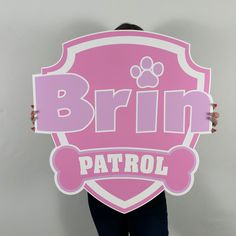 a woman holding up a pink sign with a paw on it