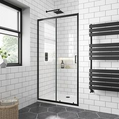 a white tiled bathroom with black accents