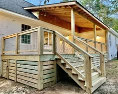 a house with stairs leading up to the front door and second story porch on top of it