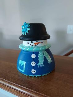 a blue and white snowman sitting on top of a wooden table