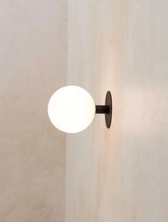 a light that is on the side of a wall in a room with white walls