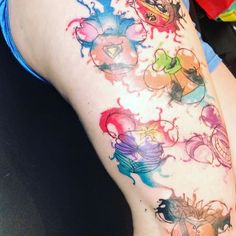 a woman's leg with tattoos on it and various colored ink splatters