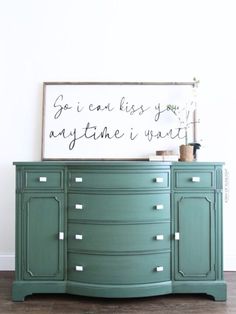 a green dresser with a sign above it