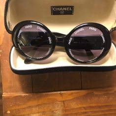 Authentic Chanel Vintage Round Sunglasses "Chanel Paris" Black With White Text These Authentic Vintage Chanel Sunglasses Are In Excellent Pre-Owned Condition And Are Absolutely Fabulous, Stunning! I Hate To Part With These But I Have Worn Them Sparingly And Carefully. There Are Very Little Signs Of Wear, Maybe The Slightest Of Small Marks And Normal Use Looks. The Frames Remain Free Of Any Large Scratches And/Or Other Blemishes. The Lenses Demonstrate No Visible Scratches And Are Encircled With "Chanel" And "Paris" In White Text Against The Terrific Black Frames And Lenses. These Sunglasses Make A Huge Fashion Statement. The Outside Of Each Temple Has The Iconic Cc Logo In Gold T Chanel Vintage Sunglasses, Vintage Chanel Sunglasses, Chanel Butterfly Sunglasses, Vintage Round Sunglasses, Sunglasses Chanel, Sunglasses Box, Round Sunglasses Vintage, Sunglasses Logo, Black Frames