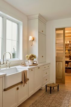 a kitchen with white cabinets and an area rug in front of the sink that is on the floor