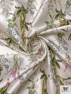 a white fabric with flowers and leaves printed on it's side, as well as the