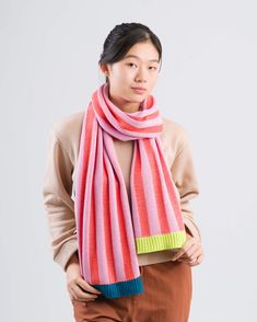 a woman wearing a pink scarf and brown pants