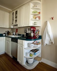 a kitchen with white cabinets and green counter tops on top of a hard wood floor