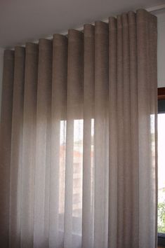 an open window with curtains hanging in front of it