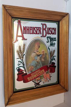 an antique advertisement hangs on the wall next to a wooden framed sign that reads,