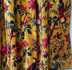 a yellow floral curtain with pink flowers on it