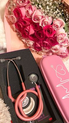 a pink box containing a stethoscope, flowers and a case with writing on it