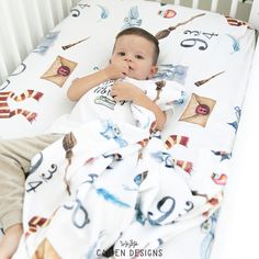 a small child laying in a crib with his hand under his chin and looking at the camera