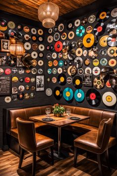 there are two boothes with chairs at the table and many records on the wall