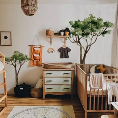 a baby's room with two cribs and a tree in the corner