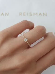 a woman's hand with a diamond ring on it