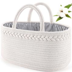 a white basket with black and white stripes on the bottom, holding a flower in it