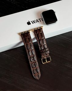 two brown alligator skin watches sitting next to each other