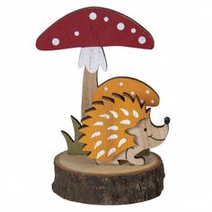 a wooden sculpture of a hedge under a mushroom on a tree stump with white polka dots