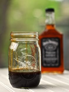 two jars filled with liquid sitting on top of a wooden table