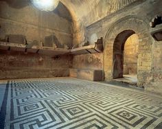 an old room with stone walls and flooring that has been decorated in greek style