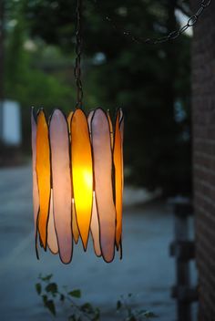 a light hanging from a chain next to a tree