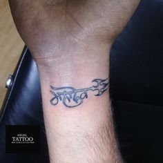 a man's wrist tattoo with the word love in cursive writing on it