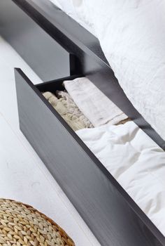 an open drawer on the side of a bed