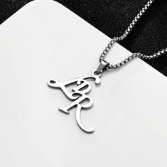 Lana Del Ray Initials Necklace Featuring a waterproof stainless steel chain and pendant coming together to form a timeless necklace.  74 cm Chain 4.1 cm x 3.7 cm Pendant The heart of this necklace is a pendant adorned with the initials LDR, elegantly crafted in stainless steel. The sleek and polished finish adds a touch of sophistication to any ensemble, making it perfect for both casual wear and formal occasions. Whether you're a devoted fan or simply appreciate fine craftsmanship, this necklac Timeless Necklace, Initials Necklace, Necklace Woman, Sweater Necklace, Woman Jewelry, Lana Del Ray, Initial Pendant Necklace, Initial Pendant, Stainless Steel Chain